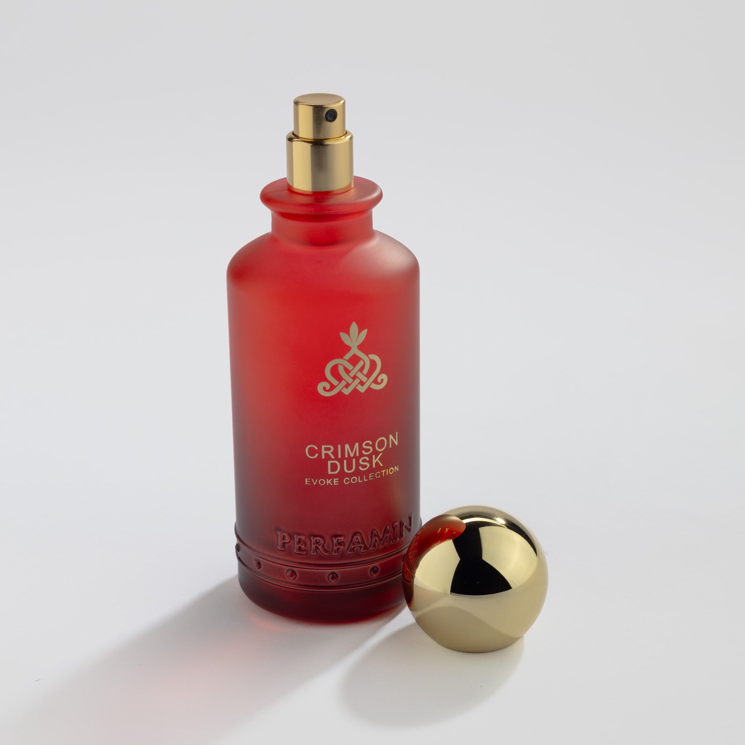 Crimson Dusk Eau de Parfum bottle with gold atomizer and Perfamin branding