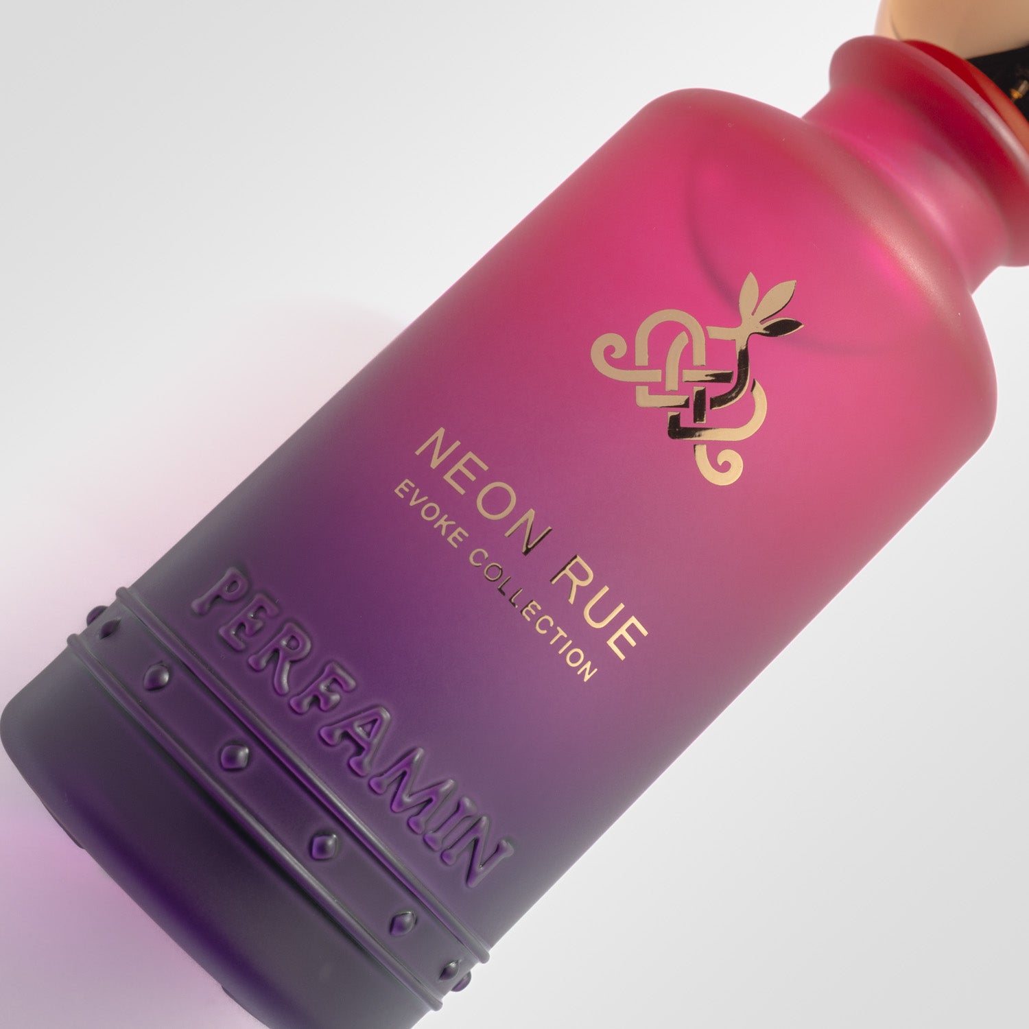 Close-up of Neon Rue Perfamin perfume bottle with fruity floral musk scent profile