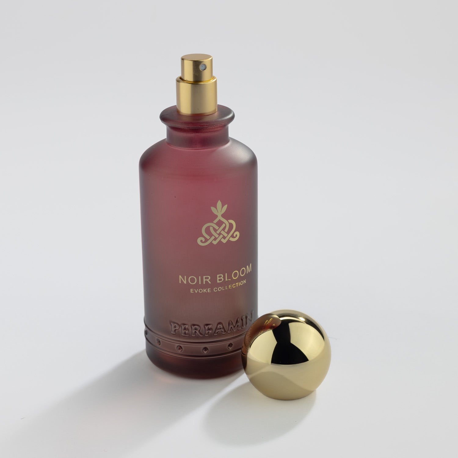 Noir Bloom Eau de Parfum bottle with gold atomizer and Perfamin branding